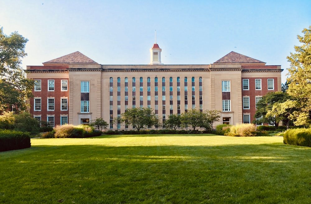 a large college building with a lawn in front of it