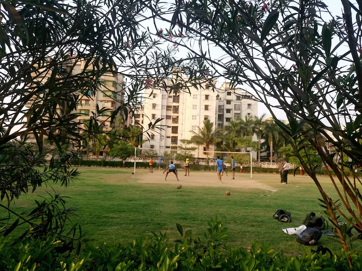 Lively scene from Jawaharlal Nehru University (JNU) campus showing students interacting and participating in activities near red-brick academic buildings, surrounded by green spaces — highlighting the university’s facilities and vibrant student life.